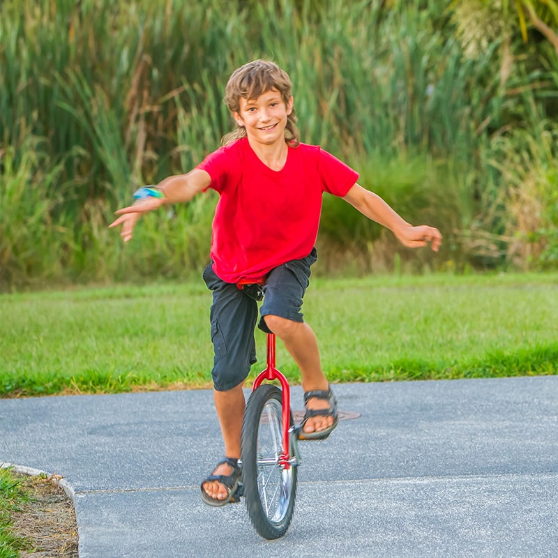 A boy rides a unicycle checked out from the Glenn A Jones MD Memorial Library