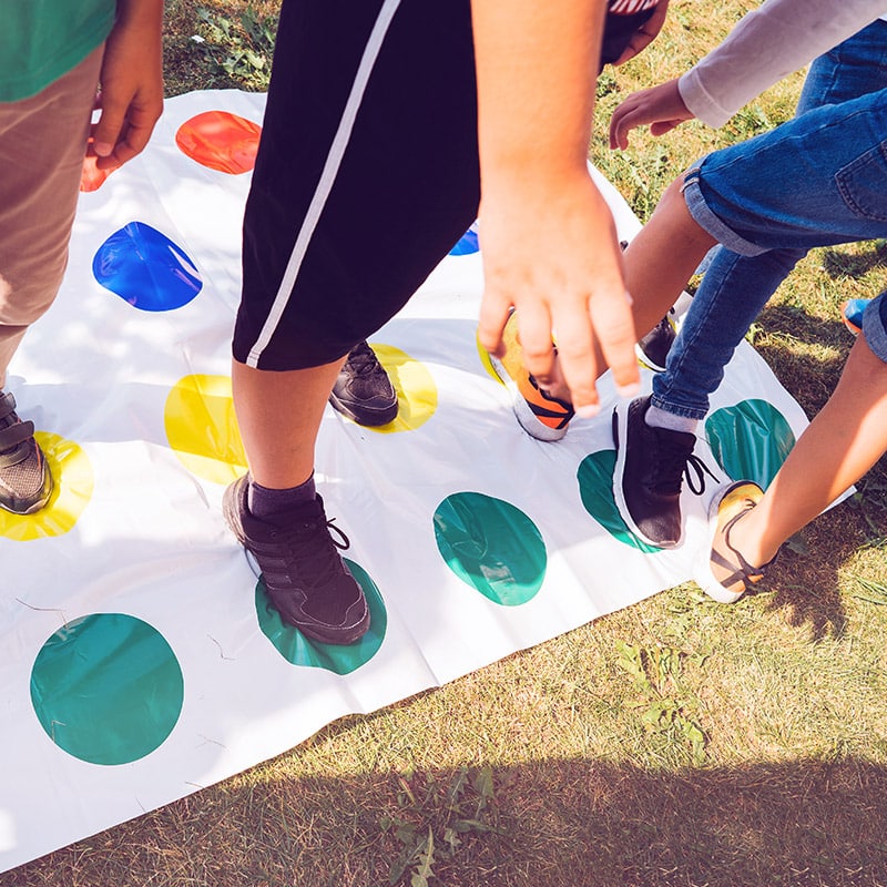 A group of kids play giant twister checked out from the Glenn A Jones MD Memorial Library