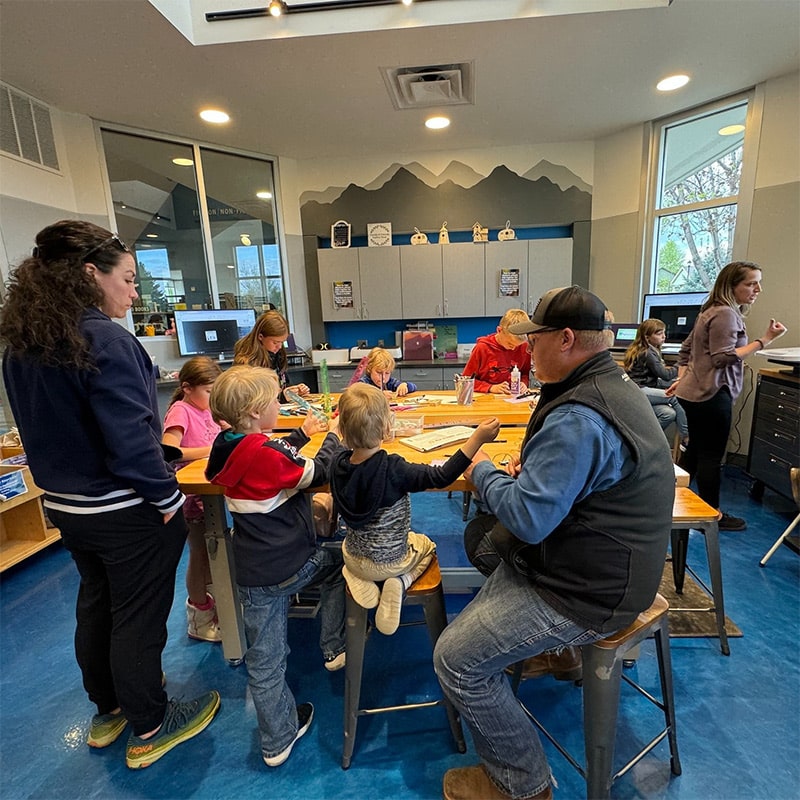 A group of children and adults creating unique hand-crafted items at the Glenn A Jones MD Memorial Library Makerspace