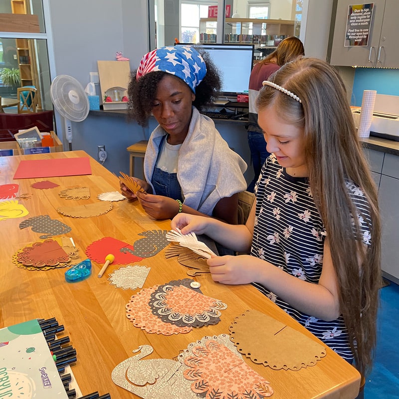 Two girls creating holiday decorations at the Glenn A Jones MD Memorial Library Makerspace
