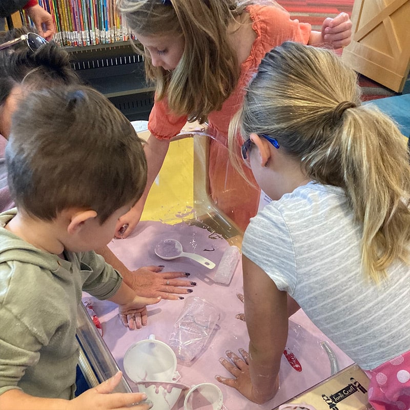 A group of children finger paint at the Glenn A Jones MD Memorial Library Makerspace